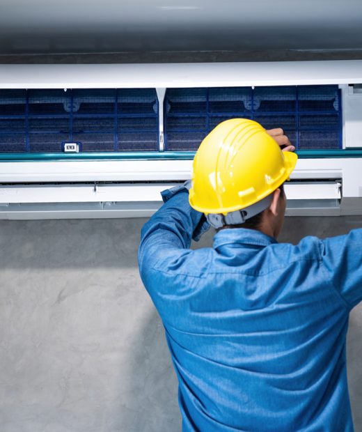 Technician man repairing ,cleaning and maintenance Air conditioner on the wall with screw driver in bedroom or office room.On site home service,Business ,Industrial concept.